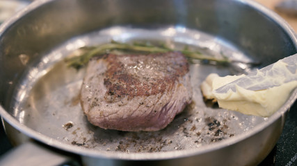 Delicious meat steak fried in a pan with rosemary