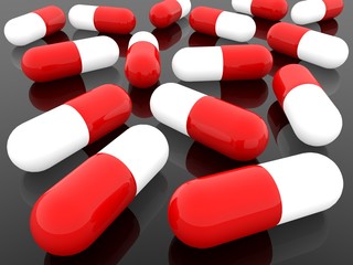 Red and white medical pills on black background