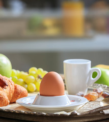 Breakfastserved, Fresh fruits, croissants, egg in eggcup and coffee on old silver tray.