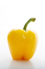 Yellow bell pepper with stem isolated on white background. Vertical portrait