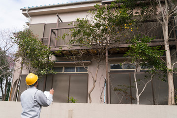 住宅とヘルメットのビジネスマン　現地調査　