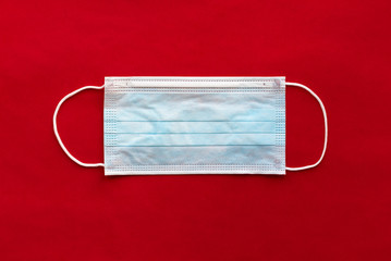 Protective face mask on red background. Medical mask. Virus and disease protection concept.