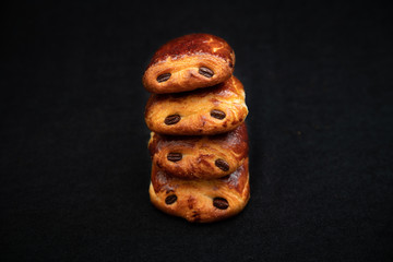  Chocolate buns stacked on top of each other, on dark background