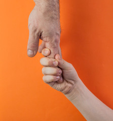 Obraz premium father's hand and child son over color background, trust family concept