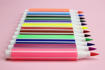 Fototapeta premium colored markers in a row on a pink background