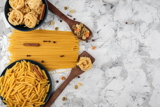 blue ceramic dishes and two wooden spatulas with various pastes and spices on a gray-white textured background