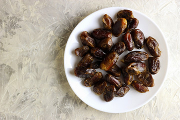 Dates from the Middle East on a white plate with a light background, place for text