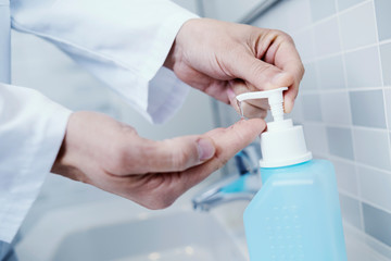 doctor disinfecting his hands with hand sanitizer.