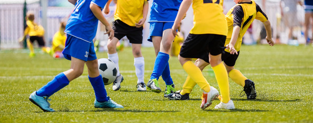 Naklejka premium Soccer Shot. Young Boys Kicking Football Soccer Tournament Match on the Grass Pitch. Football Players Duel. Running Soccer Players from Youth School Soccer Teams