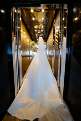 bride in mirrored Elevator with bouquet. rear view