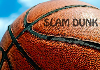 Slam dunk written on an orange basketball