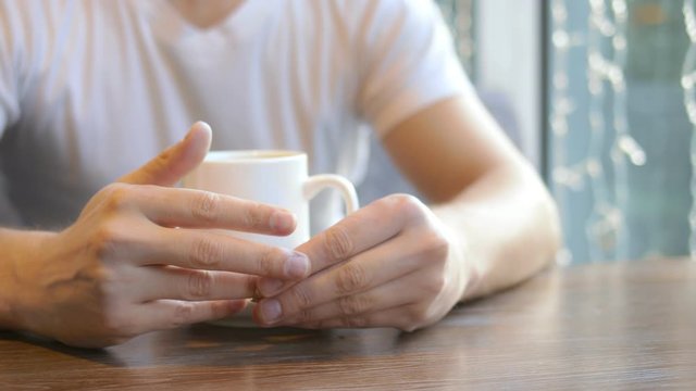 closeup. the man wears a wedding ring, sitting in a cafe.