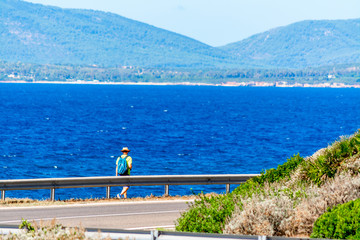 Hiker walking by the sea on a sunny springtime day