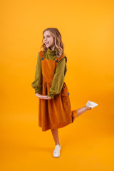 Smiling little girl wearing a dress standing isolated