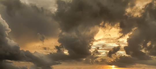 Grey clouds and orange sky at sunset