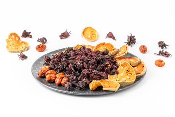 Thai herbs dried, such as roselle, quince, jujube, Chinese medicinal properties. Hypertension, heart disease on a black ceramic plate, white background