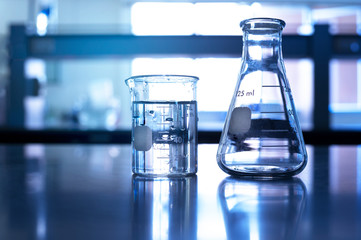 glass beaker and flask in blue medical science laboratory background