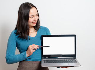 beautiful business woman smile sitting at the desk looking at camera, point finger at isolated white laptop screen