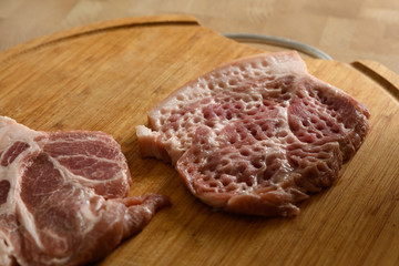 sliced raw pork meat for chops on a wooden cutting Board
