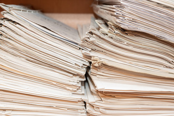Old paper documents stacked in archive. Documents on the shelves of archive room. Office shelves in the closet full of files