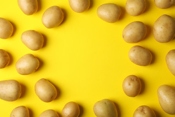 Young potato on yellow background, top view and space for text