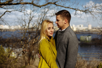 guy hugs a beautiful girl in the park