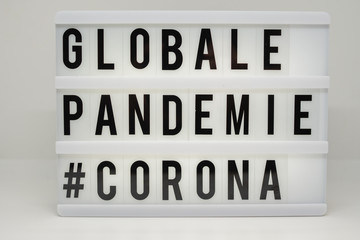 a light box with the inscription: GLOBALE PANDEMIE #CORONA with white background