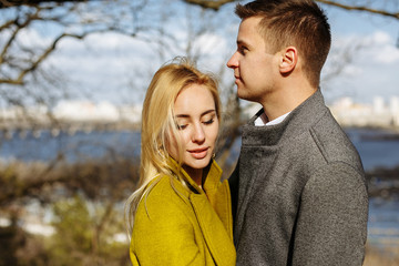 Fototapeta premium guy hugs a beautiful girl in the park