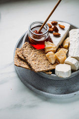 Assortment of organic cheeses on stone background. Top view with copy space. Tasty cheese starter.