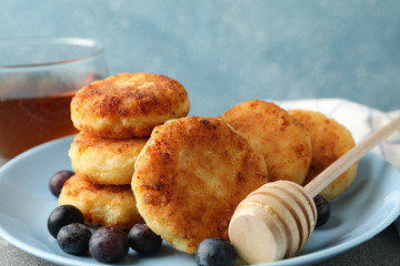 Breakfast of cheese pancakes against blue background, close up