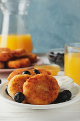 Breakfast of cheese pancakes on white wooden background, close up