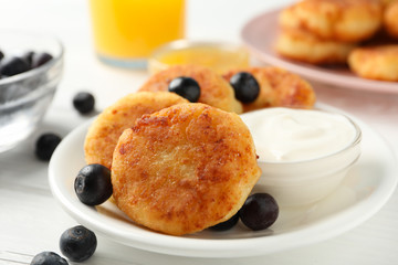 Breakfast of cheese pancakes on white wooden background, close up