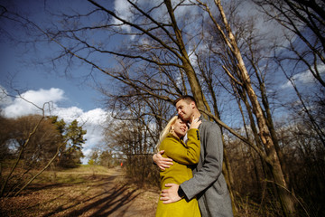 hugs of two lovers on the background of the park and sky