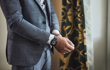 Businessman wears a jacket,male hands closeup,groom getting ready in the morning before wedding ceremony