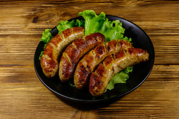 Tasty grilled sausages on a wooden table