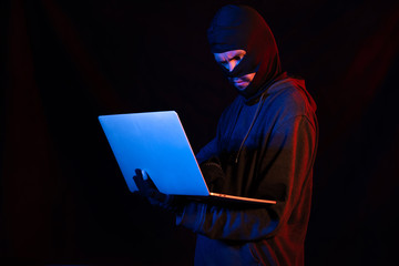 Burglar with computer - isolated on black