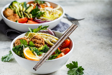 Buddha bowl salad with avocado, sweet potato, falafel, zucchini, tomatoes and broccoli.