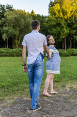 Fototapeta premium Young couple in love with a pregnant woman holds in their hands a picture of an ultrasound with an unborn baby