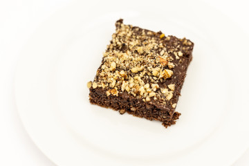 Chocolate Cake With Grated Nuts On The Plate Isolated Above White Background