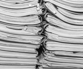 Paper documents stacked in archive. Documents on the shelves of archive room. Office shelves in the closet full of files. black and white photo