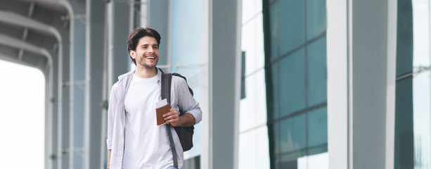 Fototapeta premium Ready For Journey. Handsome Young Man Walking Near Airport Terminal