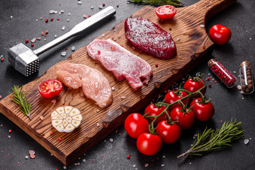Fresh juicy steak of beef, pork and chicken with vegetables ready to cook