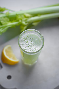 Celery juice in a  glass.  view over a rustic marble white  background.