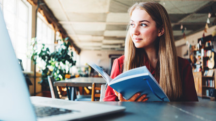 Young woman with notepad working in big loft coworking space