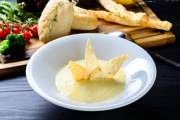 Cheese soup with toasts in blue pottery