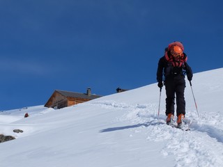 Fototapeta na wymiar Arrivée au refuge en ski de rando en montagne sous la neige en hiver dans les alpes