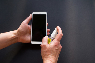 Hygiene phone washing the screen with an antiseptic. Gadget Disinfection.