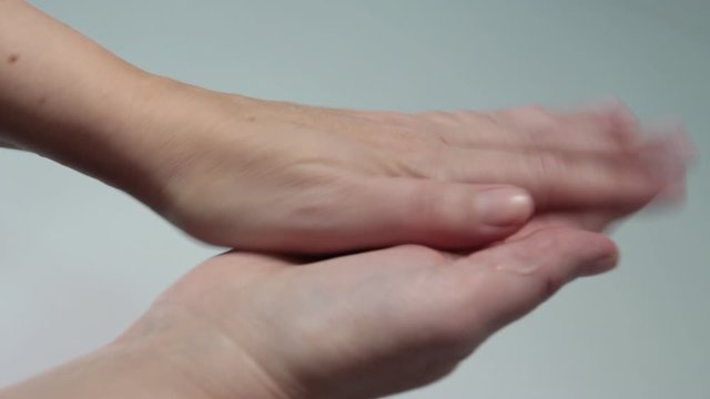 closeup, woman's hands use sanitizing gel on her hands to clean them