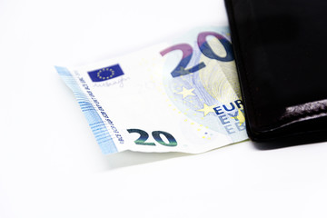 a 20 euro note comes out of a leather wallet isolated on a white background. Finance and politics.