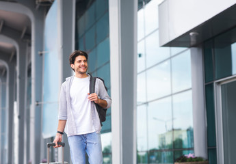 Man arriving to airport at new destination, standing outside of terminal